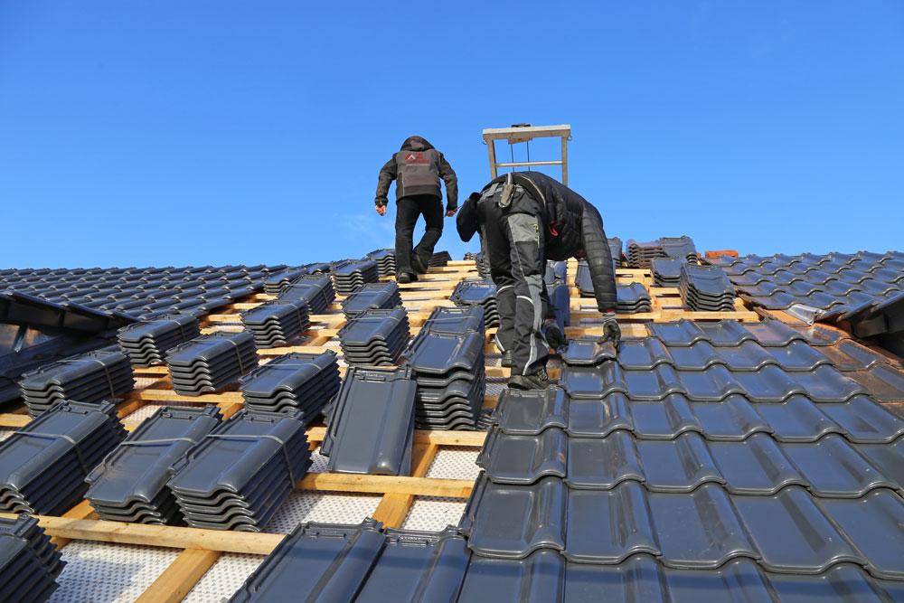 Dachdecker bei der Arbeit auf einem Steildach, Installation mit Präzision und Sicherheit